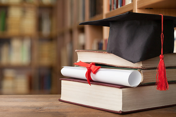 Graduation cap on top of a pile of books 